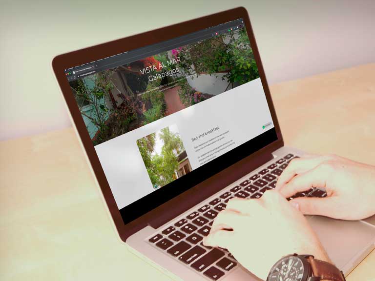 Laptop sobre un escritorio con la página web del hotel Vista Al Mar